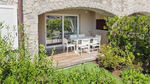 Een stenen gebouw met een terras, inclusief een tafel en stoelen.