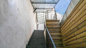 Eine Treppe mit Metallgeländern, Betonwänden und Holzverkleidung.