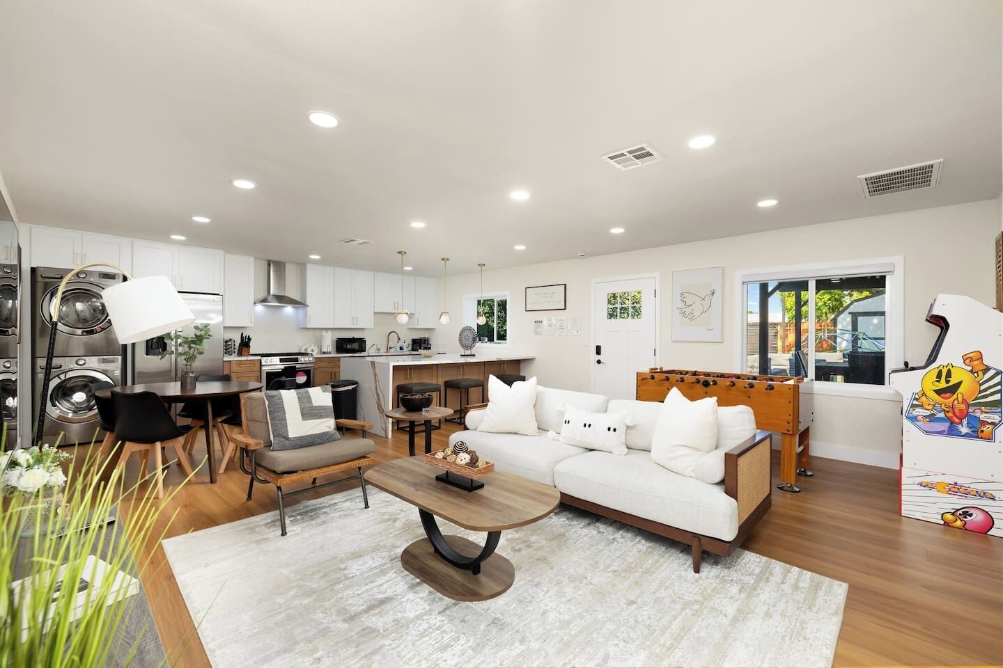 A modern living room with a sofa, coffee table, and dining area.
