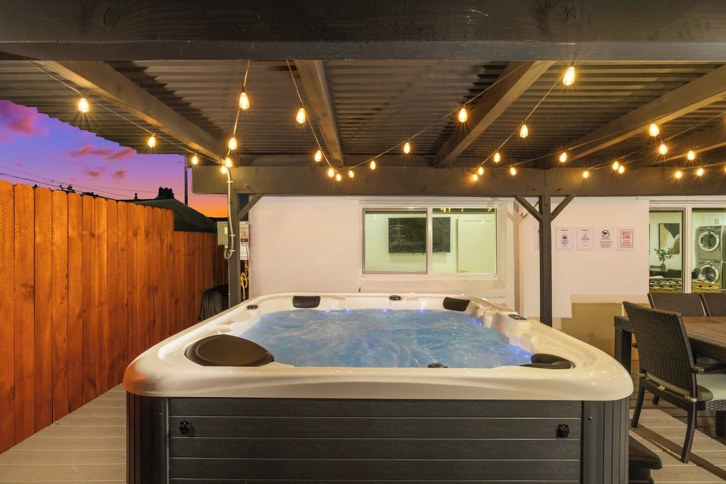 Un bain à remous avec une terrasse en bois et un espace patio couvert.