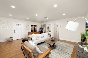 A modern living room with a sofa, coffee table, and a gaming console.