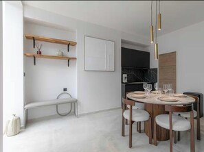 A modern dining area with a round table, chairs, and pendant lighting. - Stunning Apartment  - 4BR/8P - Gare de l'Est (Paris)