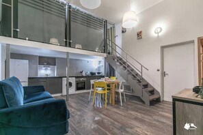 A modern apartment with a dining area, a sofa, a staircase, and a kitchen. - Duplex apartment 2BDR/6P - Center of Paris (Paris)