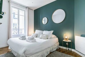 A bedroom with a bed, two bedside mirrors, a bedside lamp, and a view of the outside. - Charming apartment - 2BR/6P - Montreuil near Paris (Montreuil)