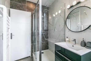 A modern bathroom with a glass-enclosed shower, a white sink, and a large mirror. - Charming apartment - 2BR/6P - Montreuil near Paris (Montreuil)