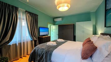 Une chambre d’hôtel équipée d’un lit, d’une télévision, d’une armoire et d’un bureau.