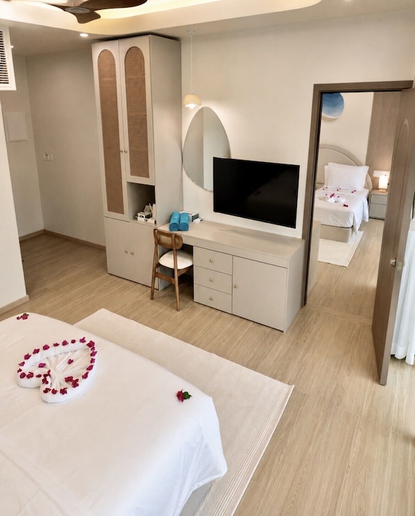 A hotel room with a bed, a desk, a TV, and a wardrobe.