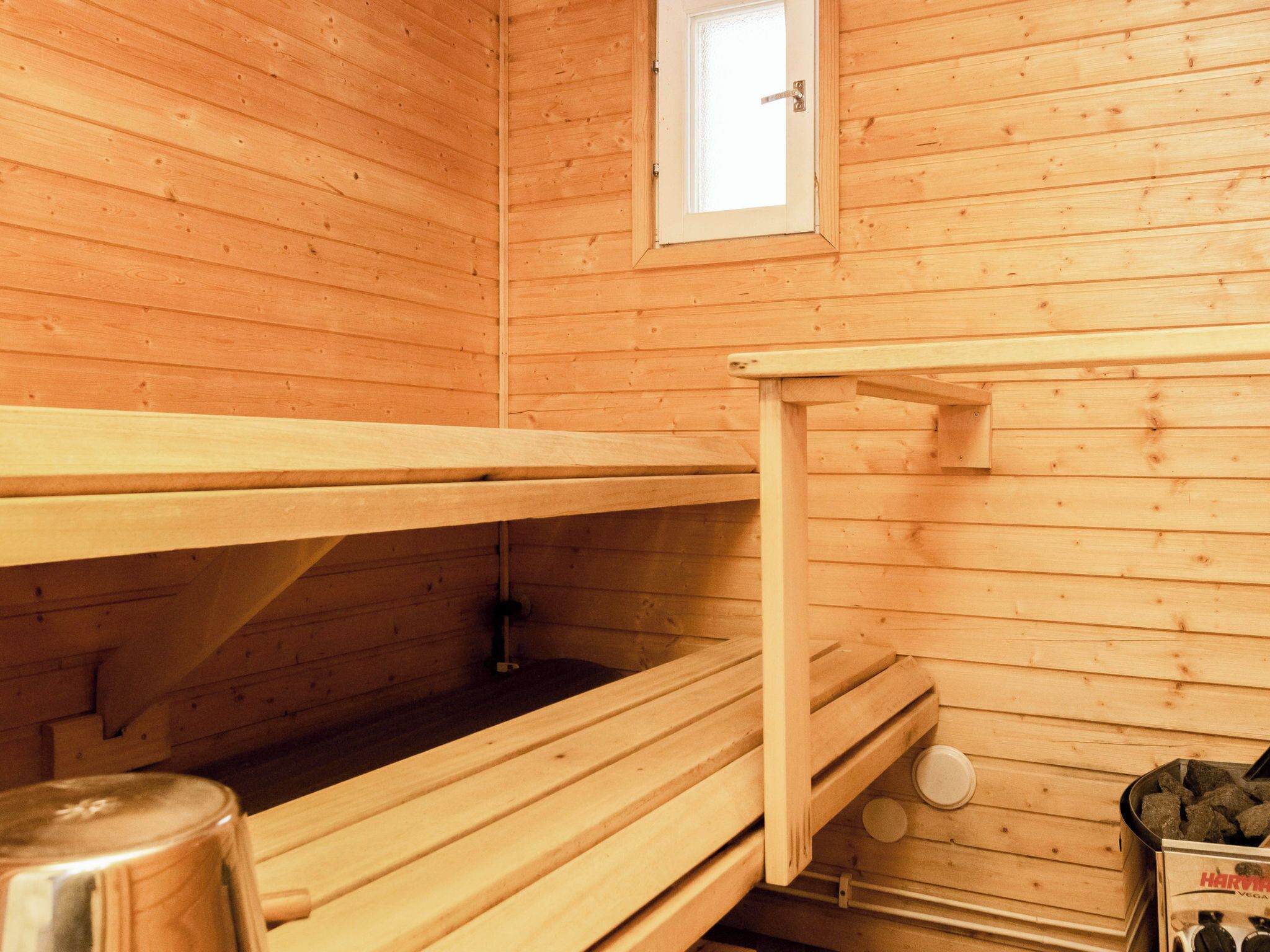 A sauna with wooden benches and a small window.