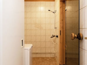 Kylpyhuone, jossa on suihku, wc ja puuovi.