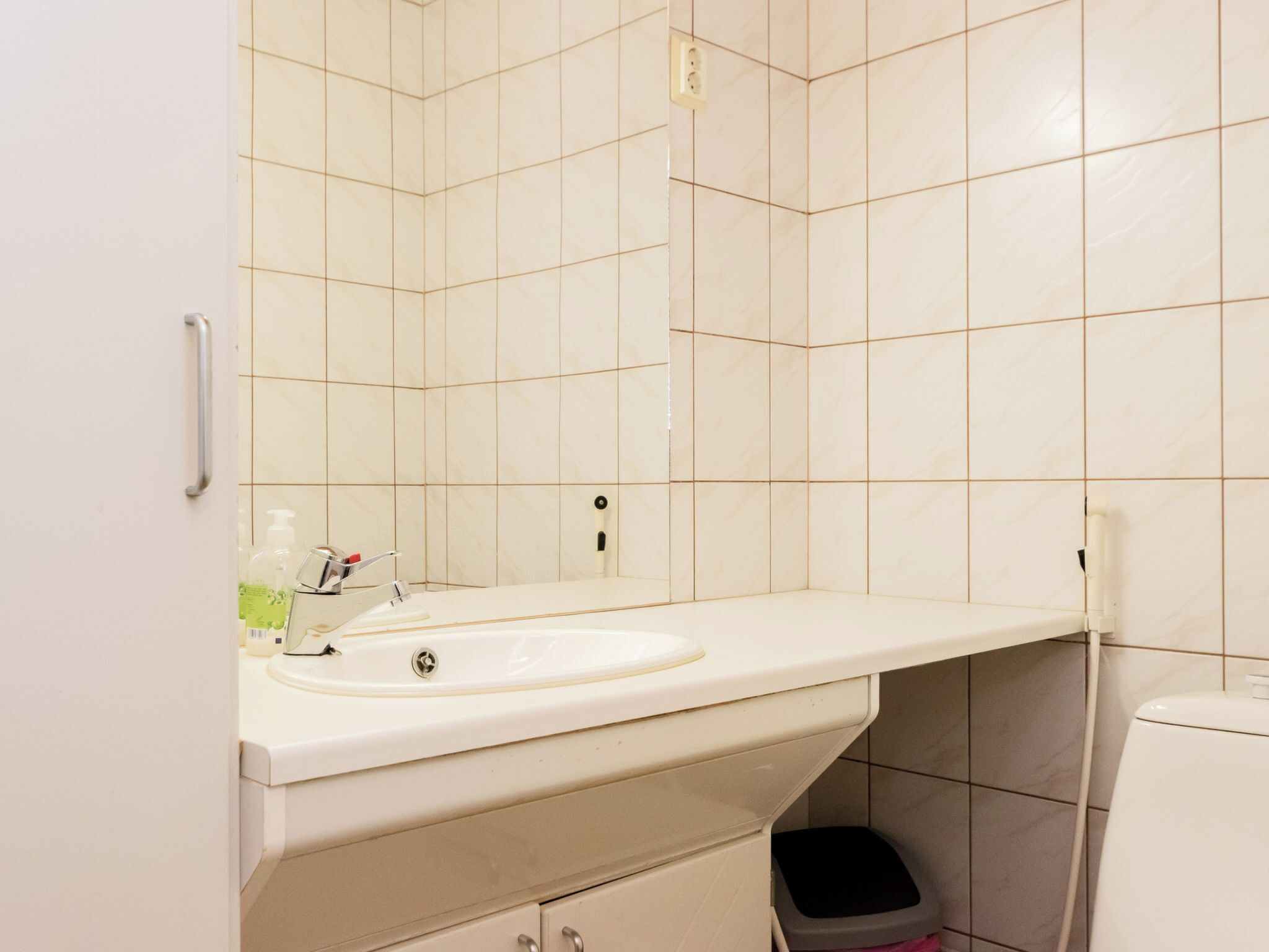 Un baño con un lavamanos blanco, un espejo y un inodoro.