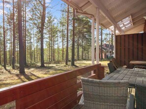 A covered outdoor seating area with a view of a forest. - Koli country club b 6 by Interhome (Lieksa)