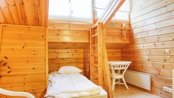 Une pièce dans un chalet en bois, comprenant un lit, une table et une chaise.