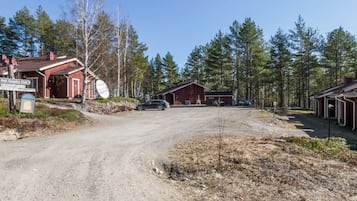 Maalaismaisemassa kulkeva tie johtaa punaiseen rakennukseen, jonka edessä on kyltti, jossa lukee Koli Country Club.