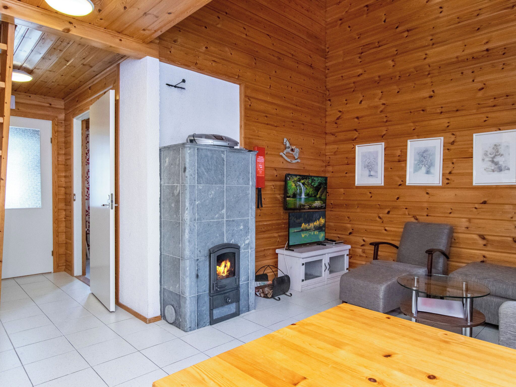 Ein gemütliches Zimmer mit Kamin, Fernseher und einer Sitzecke.