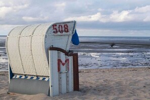 A beach chair with a number '508' and a letter 'M' on it, placed on a sandy beach with the ocean in the background. - 11 in the Villa Meeresblau (Cuxhaven)