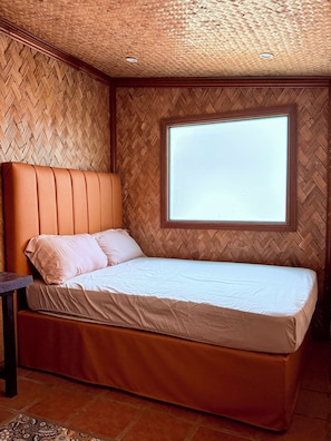 Una cama individual con cabecera de madera y una ventana encima.