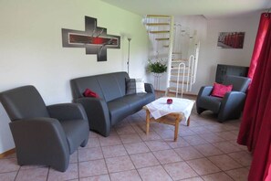 A living room with a sofa, two armchairs, a coffee table, a TV, and a staircase. - 1 on the Grafel farm (Kirchlinteln-Stemmen)
