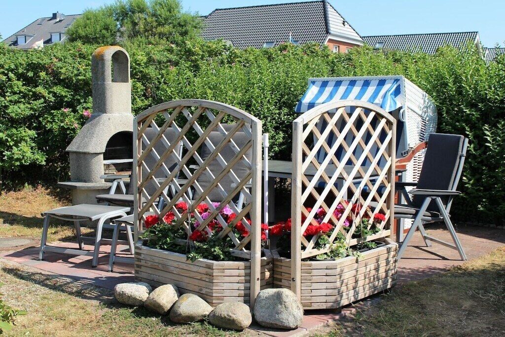 A garden with a stone oven, a lattice fence, and a covered seating area.
