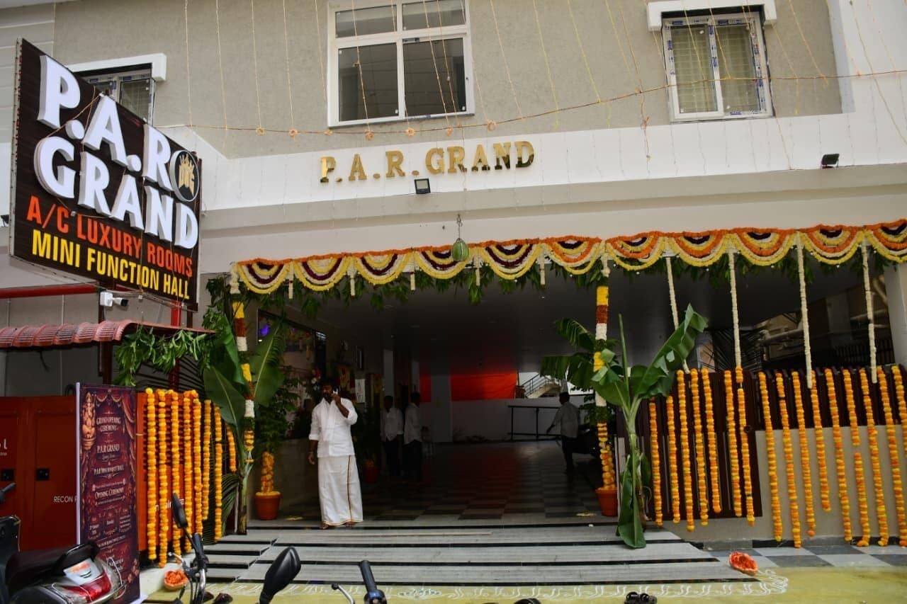 L'entrée d'un hôtel, avec une enseigne indiquant « P.A.R. GRAND » et « CHAMBRES DE LUXE CLIMATISÉES, PETITE SALLE DE RÉCEPTION ».