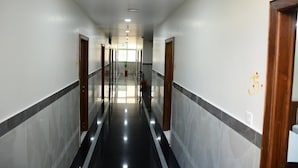 A hallway with a polished floor, doors on both sides, and a number '35' on the wall. - P A R GRAND LUXURY HOTEL  (Anantapur)
