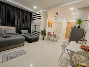 Un dormitorio moderno con cama, mesitas de noche, un escritorio y un rincón comedor con sillas y una mesa.