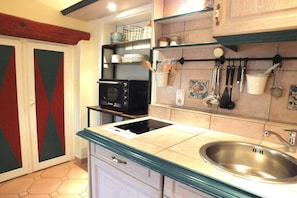 A kitchen with a stainless steel sink, a microwave, and a glass countertop. - at Klönhus / Captain Sun (Ostseebad Prerow)