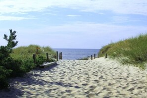 A sandy beach path leading to the ocean, surrounded by grass and wooden posts. - Holiday apartment Zaunkönig (Ostseebad Zinnowitz)