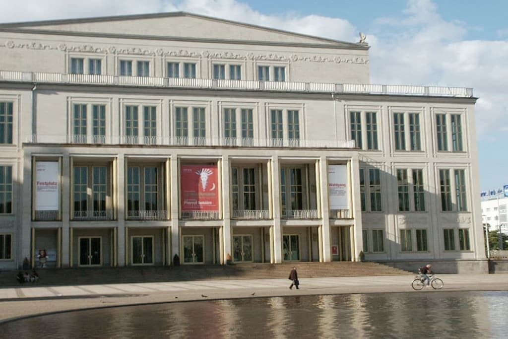 Een groot, meerlaags gebouw met een symmetrische gevel, grote ramen en een centrale ingang.