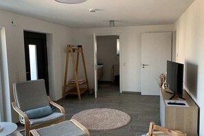 Ein Wohnzimmer mit Fernseher, Staffelei und Stuhl.