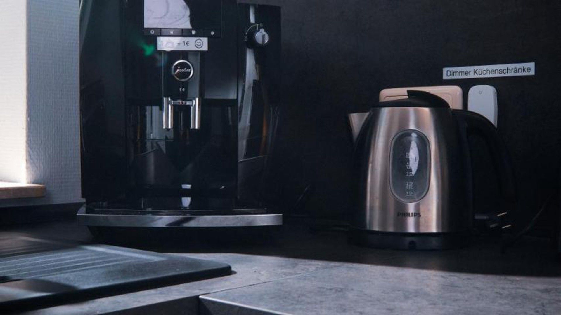 A coffee machine and a kettle on a countertop.