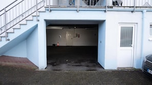 Entrada d'un edifici amb escala, una porta i un extintor.