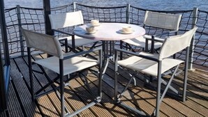Een tafel met vier stoelen en twee bekers, omgeven door een metalen hek.
