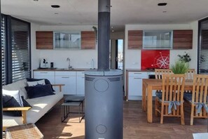 Un espacio habitable moderno con sofá, mesa de comedor, sillas y un calentador central.