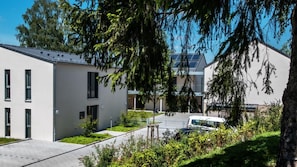 Ein modernes Gebäude mit flachem Dach, großen Fenstern und einem Parkplatz.
