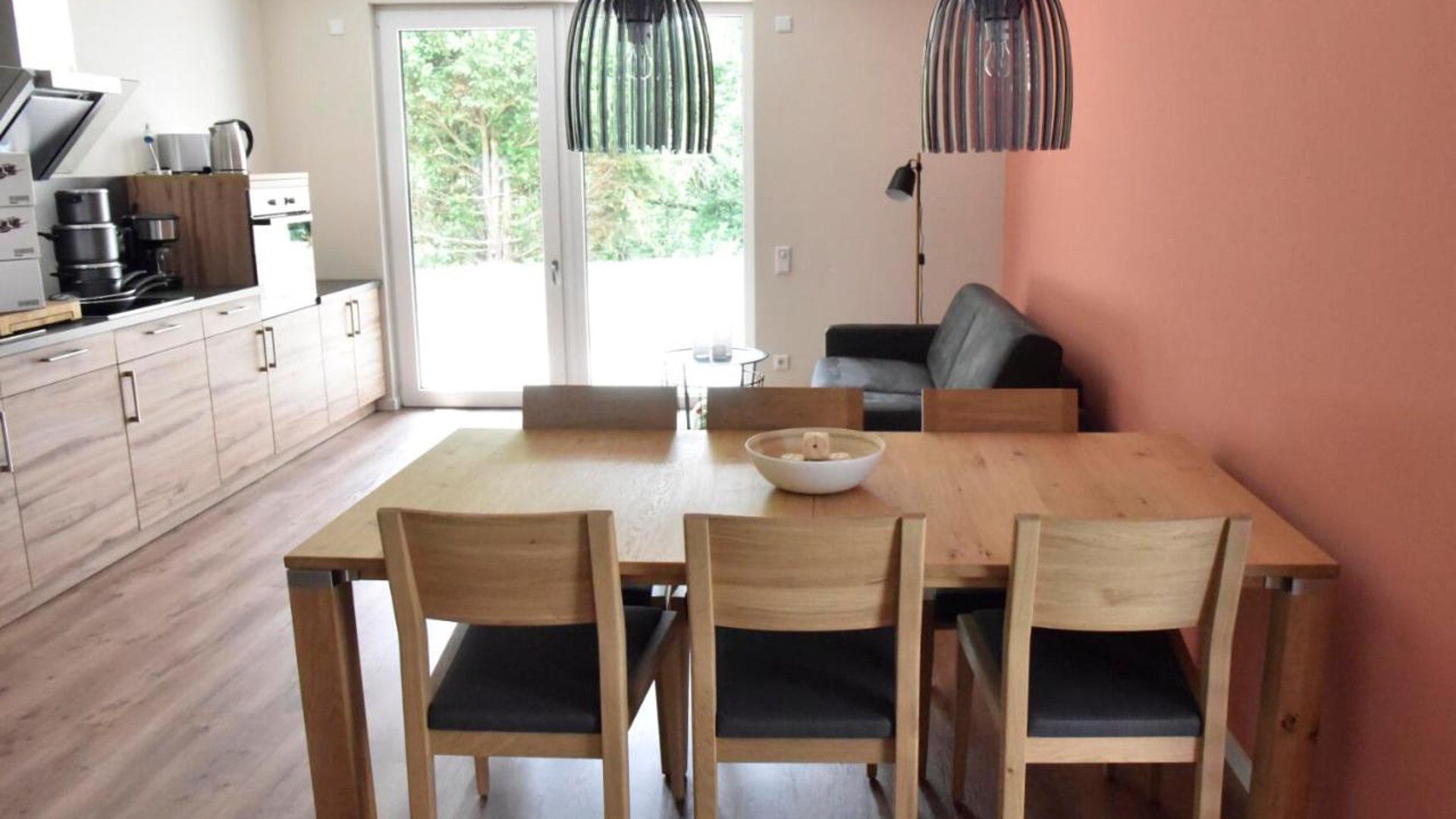 A modern kitchen with wooden cabinets and a dining table with chairs.