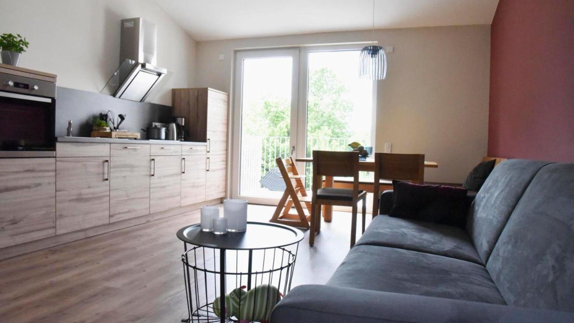 A modern living space with a kitchen, dining area, and a sofa.