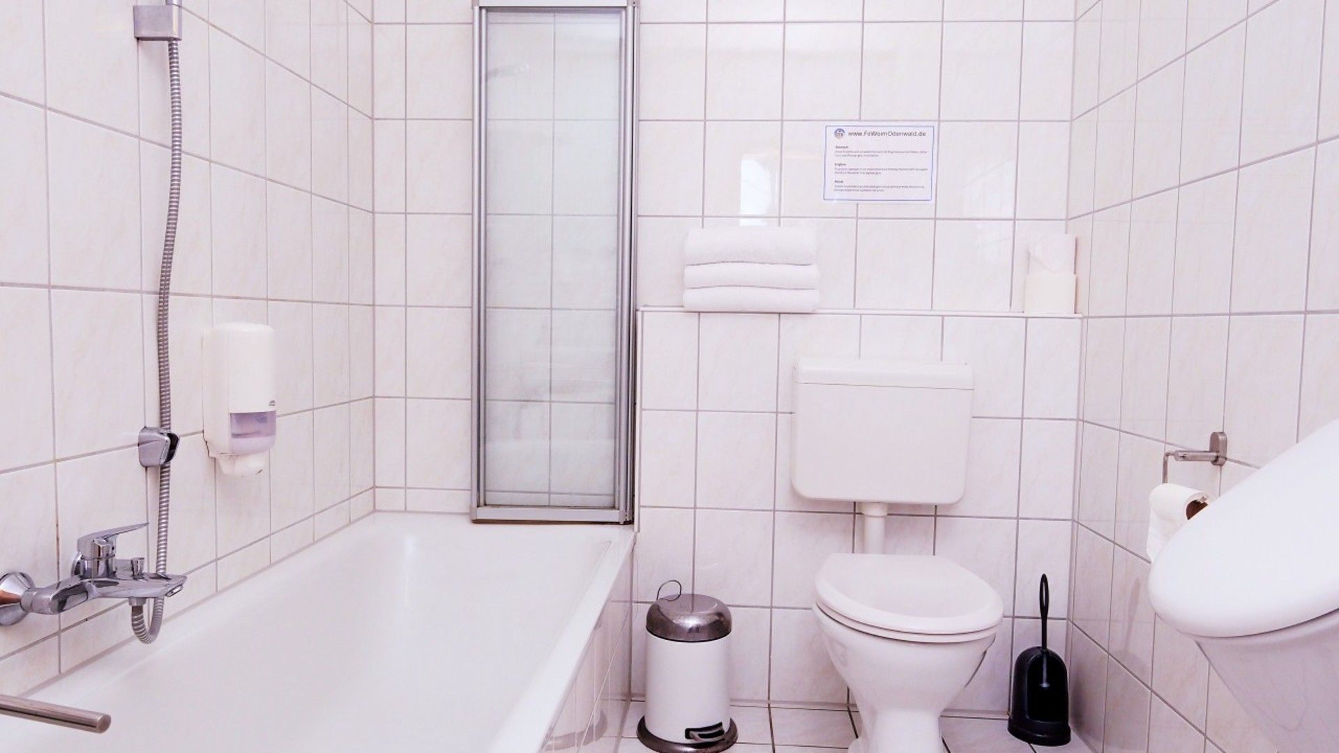 A bathroom with a bathtub, toilet, and a shower enclosure.