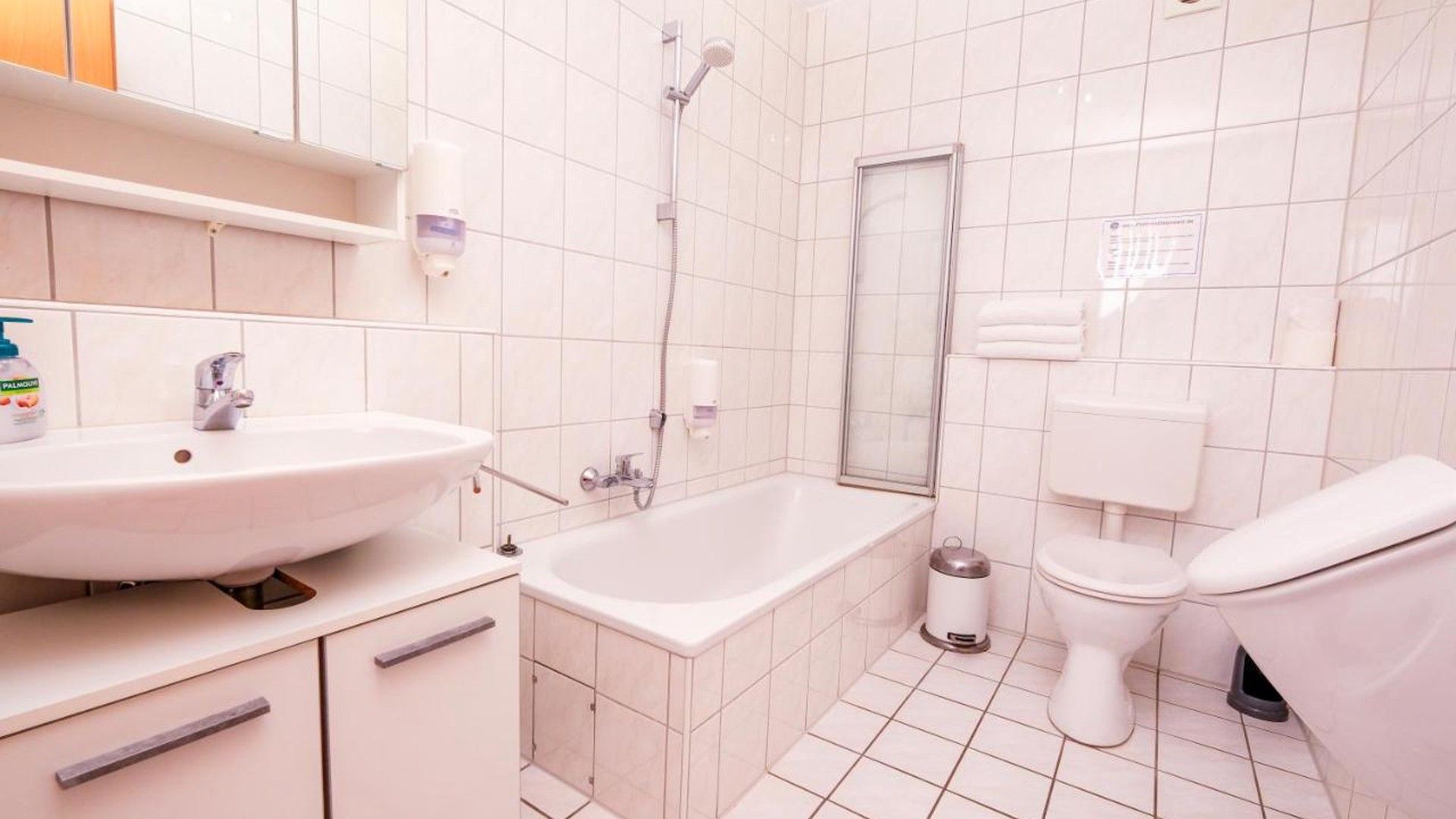 Ein modernes Badezimmer mit Waschbecken, Badewanne, Toilette und Dusche.