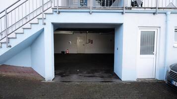 Ein Gebäudeeingang mit Treppe, Tür und Feuerlöscher.