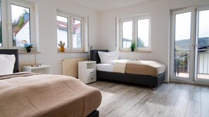 Ein Schlafzimmer mit einem Bett, einem Nachttisch, einer Kommode und einem Fenster.
