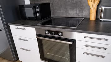 A kitchen with a microwave, toaster, and oven.