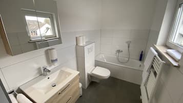 A bathroom with a sink, toilet, and bathtub.