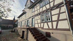 A traditional half-timbered building with a staircase leading to the entrance. - Zur Traube Blue – Half-Timbered Flat, Erbach (Erbach)