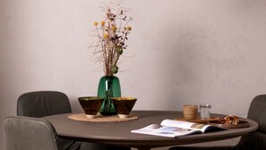 A round table with a magazine, a bowl, a glass, and a decorative vase with dried plants. - Zur Traube Green – Half-Timbered Flat, Erbach (Erbach)