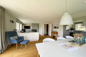 A modern interior with a dining area, kitchen, and seating space. - Wadden Sea pearl Bredland (Nieblum)