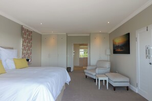 A bedroom with a bed, a chair, a desk, and a wardrobe. - Stunning house on Pezula Championship Course, 4 bedrooms ensuite, private pool (Knysna)