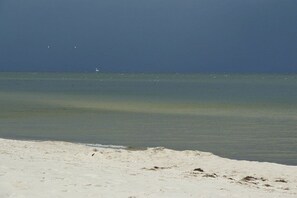 Ein Strand mit klarem Wasser und sandigem Ufer.