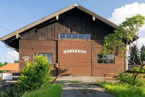 Ein Holzgebäude mit der Aufschrift 'HUBERHOF' und der Nummer '20' an der Fassade.