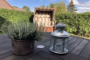 A potted plant and a lantern on a wooden deck. - Holiday apartment with 1 bedroom (Dornum)
