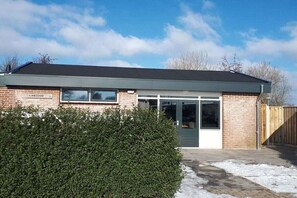 Een gebouw met een bord waarop 'LAMSOOR' staat en een groot raam.